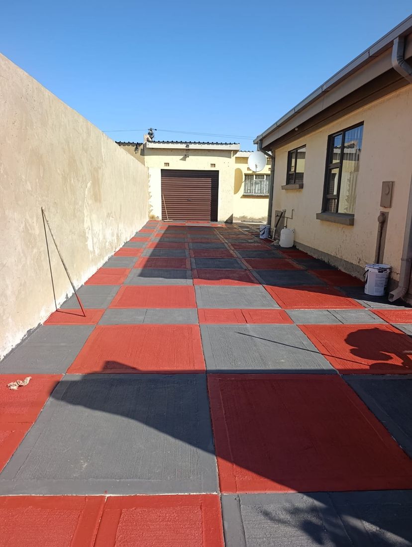Bold red, charcoal and grey checkerboard decorative concrete driveway