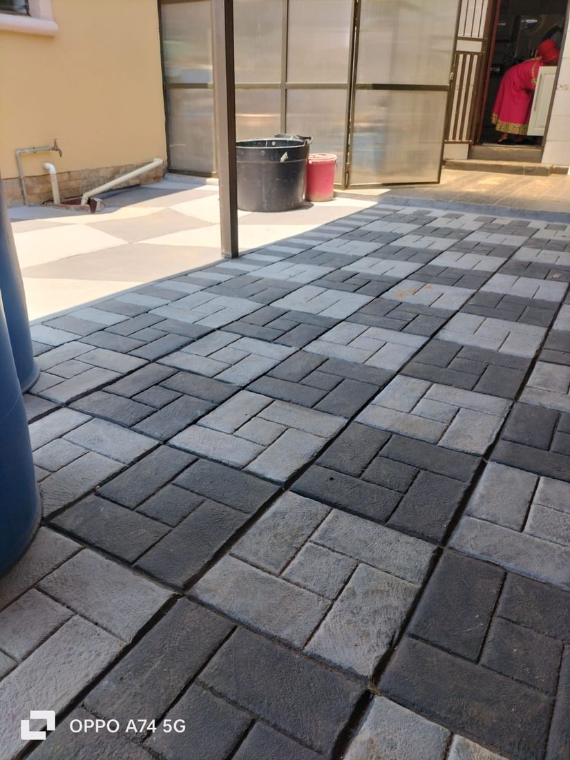 Charcoal and grey pinwheel-pattern brick paved driveway