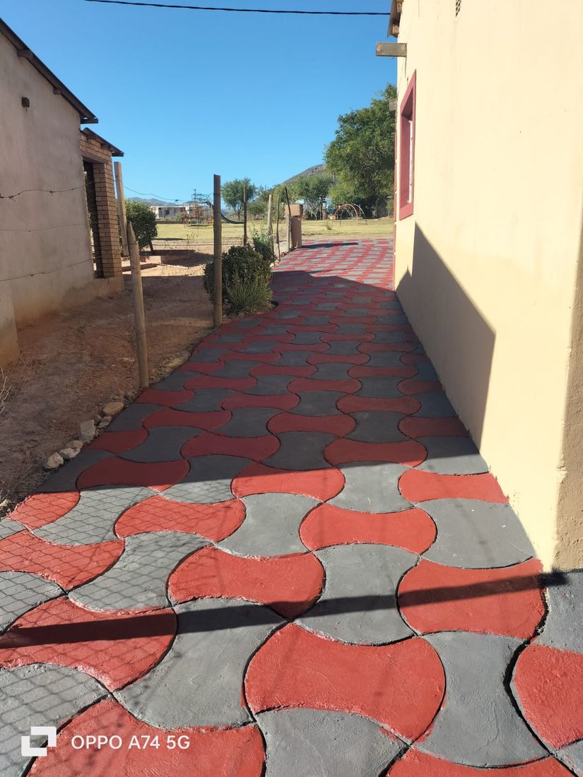 Red and orange wave pattern decorative concrete walkway under blue sky